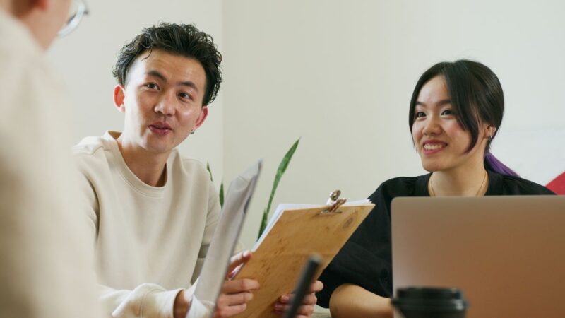 資料を見ながら相談する社員